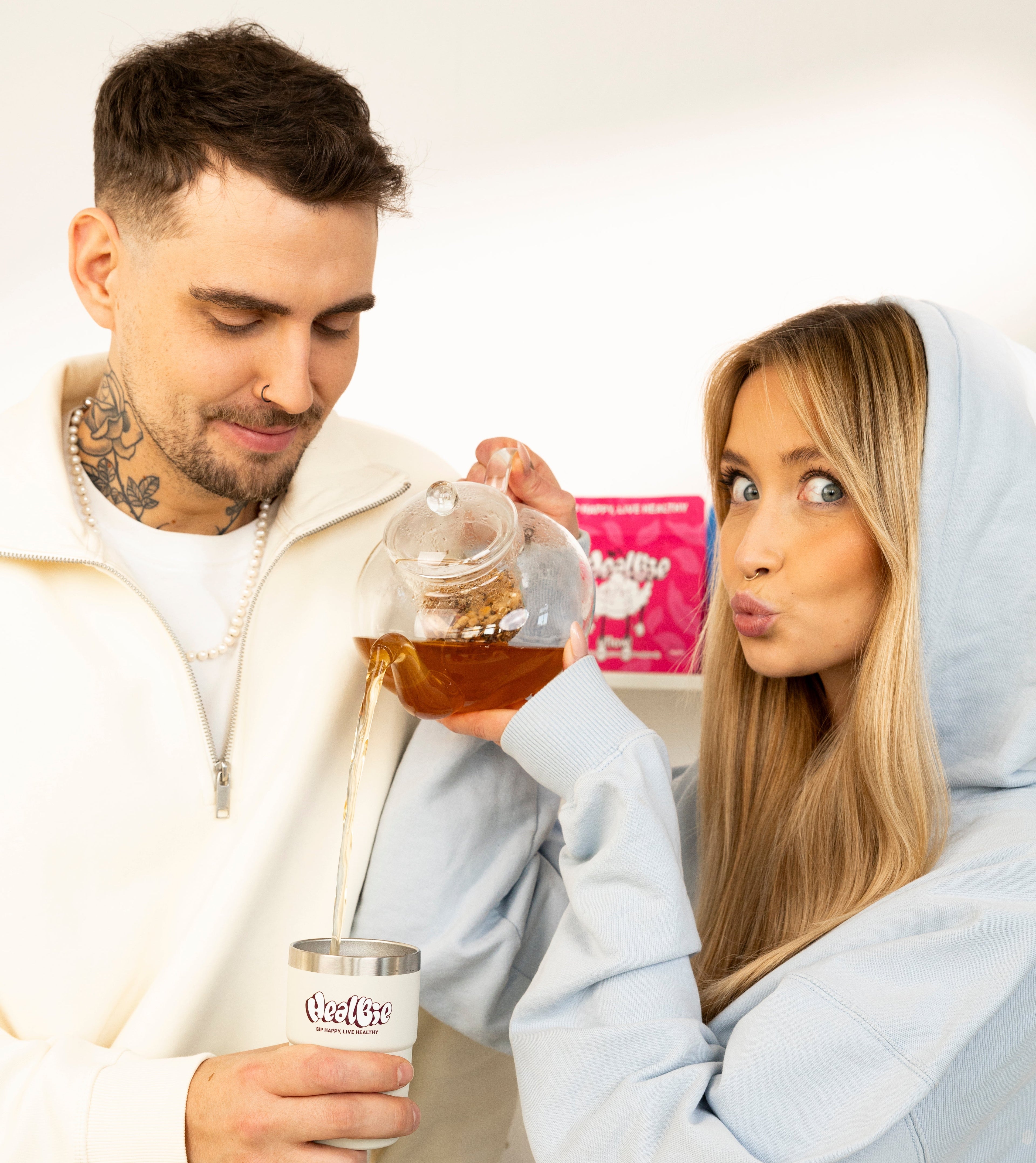 kubek termiczny w jasnym kolorze ze stali nierdzewnej i zaparzone ziółka 