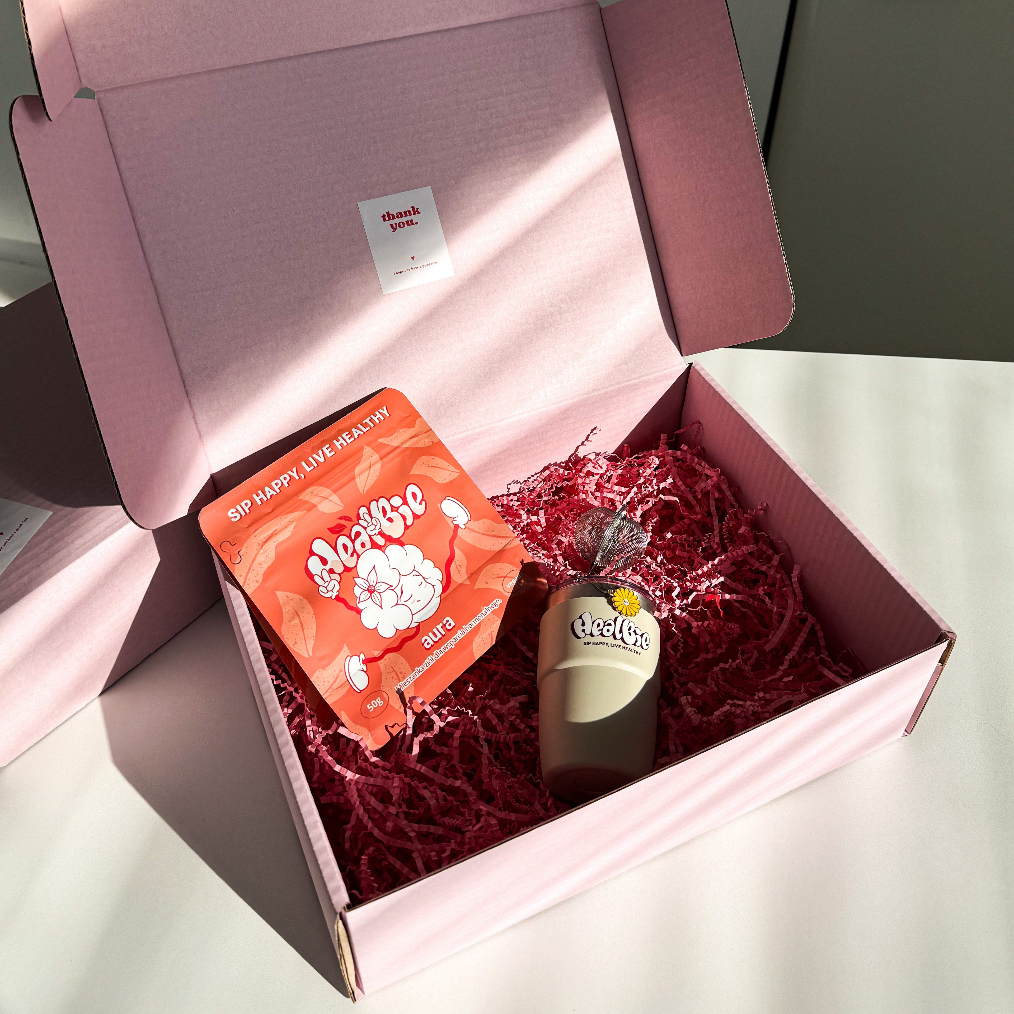 box z ziołową herbatą, kubek termiczny, zaparzacz do herbaty